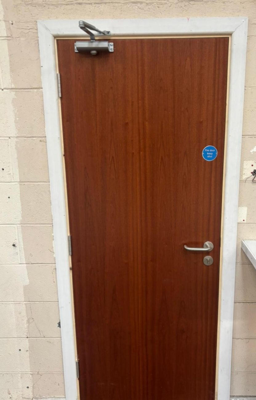 Commercial Flush Fire Door Fitting Flush timber fire door fitted with an overhead closer and statutory safety signage, supplied and expertly installed for a commercial client.