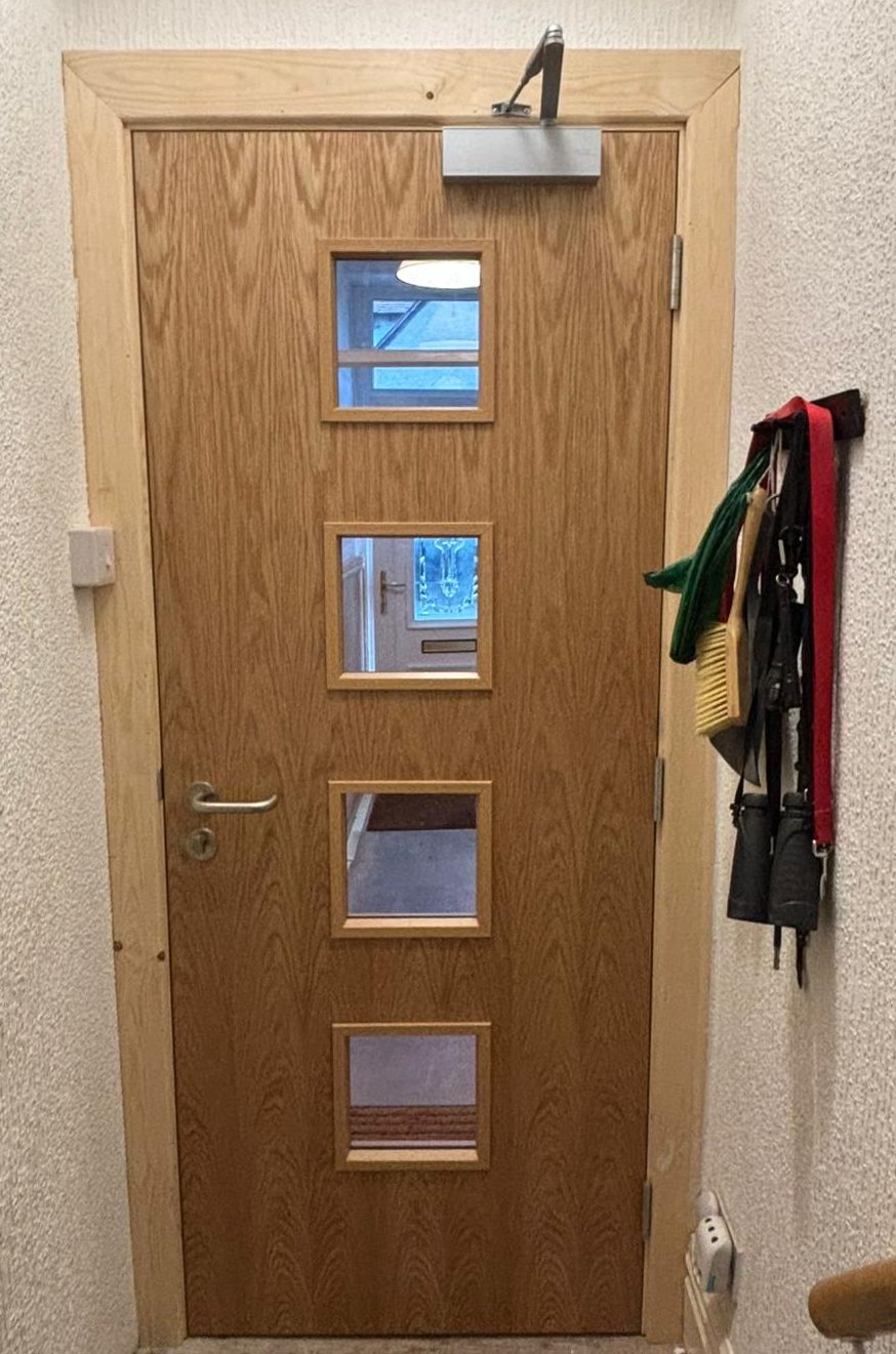 Glazed Timber Fire Door Installation Custom timber fire door with four glazed vision panels, expertly installed in a residential setting by DB Fire Doors.