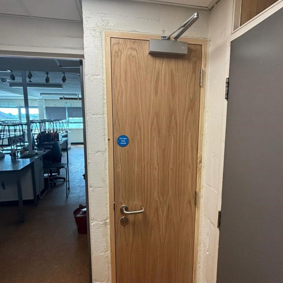 Certified internal oak fire door manufactured for the education sector, shown in a classroom setting to demonstrate durability and complianc